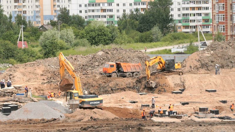 Ziegelsteine, die draußen legen Bagger lädt Lehm in LKW