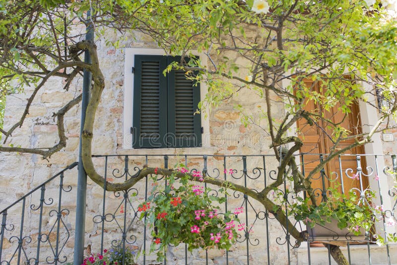 Brickstone old charming house with flowers and climbing plants in Fortunago, Italy. Brickstone old charming house with flowers and climbing plants in Fortunago, Italy