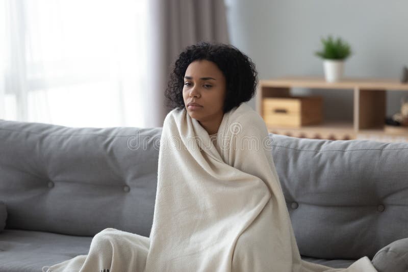 Zieke Afrikaanse vrouw die koud voelen thuis behandeld met deken