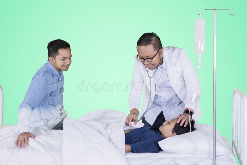 Zieke die jongen door zijn arts op studio wordt onderzocht stock fotografie Zieke die jongen door zijn arts op studio wordt onderzocht stock fotografie