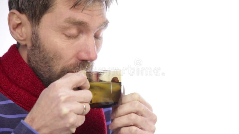 Zieke gebaarde hipster met koude en dranken hete thee met citroen