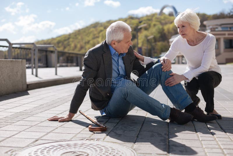 Zieke gepensioneerde die pijn in zijn knie hebben in openlucht royalty-vrije stock fotografie Zieke gepensioneerde die pijn in zijn knie hebben in openlucht royalty-vrije stock fotografie
