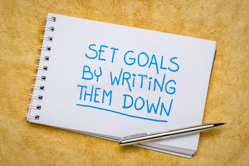 Set goals by writing them down reminder - handwriting in a spiral sketchbook, planning, setting and recording goals concept. Set goals by writing them down reminder - handwriting in a spiral sketchbook, planning, setting and recording goals concept
