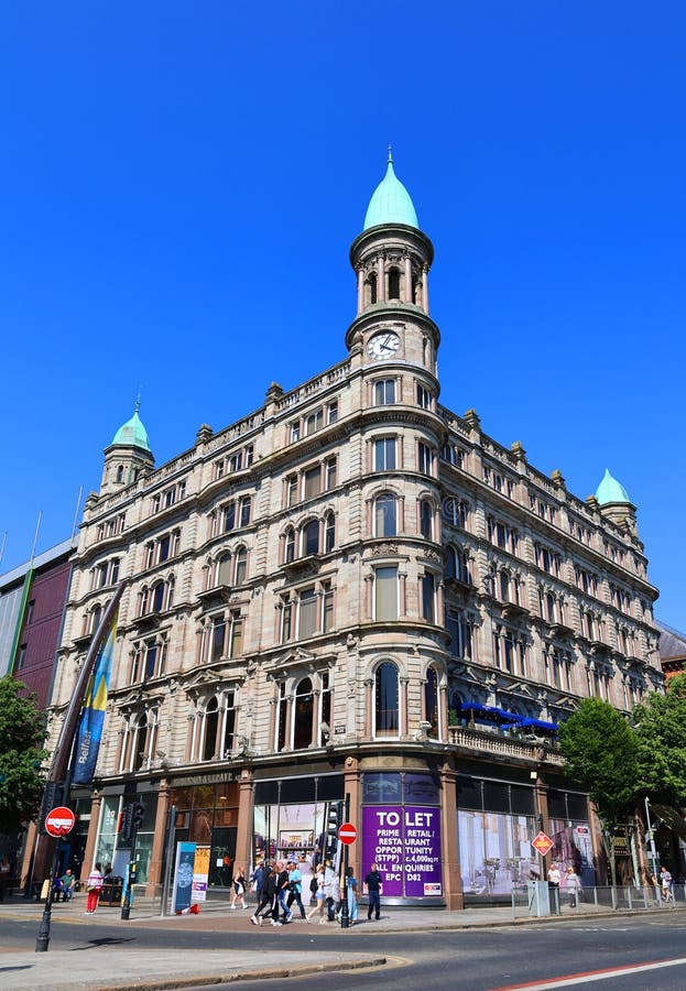 BELFAST NORTHERN IRELAND UNITED KINGDOM 06 03 2023: Green copper ogee dome and tower clock on old Robinson and Cleavers department store in belfast designed by Young and Mackenzie. BELFAST NORTHERN IRELAND UNITED KINGDOM 06 03 2023: Green copper ogee dome and tower clock on old Robinson and Cleavers department store in belfast designed by Young and Mackenzie