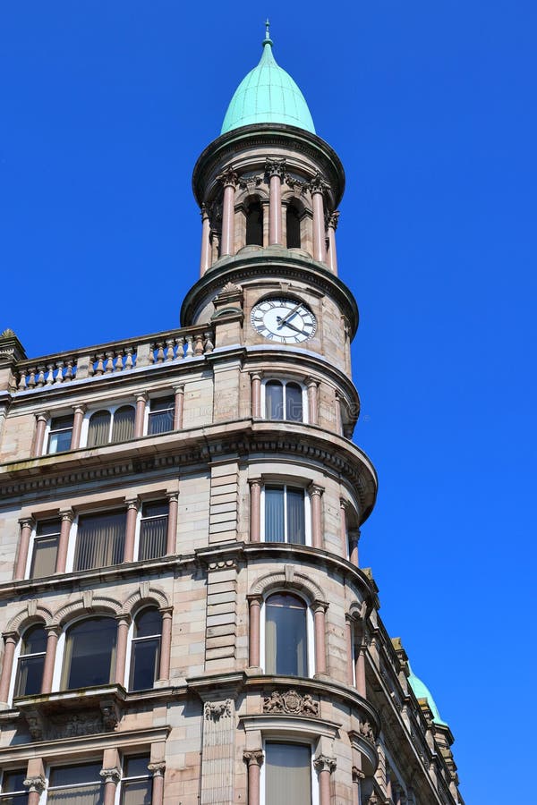 BELFAST NORTHERN IRELAND UNITED KINGDOM 06 03 2023: Green copper ogee dome and tower clock on old Robinson and Cleavers department store in belfast designed by Young and Mackenzie. BELFAST NORTHERN IRELAND UNITED KINGDOM 06 03 2023: Green copper ogee dome and tower clock on old Robinson and Cleavers department store in belfast designed by Young and Mackenzie