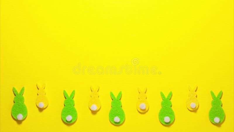 Zielone i żółte króliczki aksamitne na żółtym tle na battomie z przestrzenią do kopiowania. zatrzymaj animację ruchu płaski widok