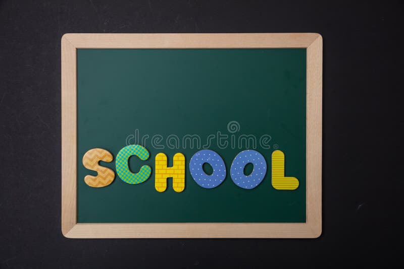 Zielony chalkboard z drewnianą ramą, słowo szkoła w kolorowych listach, czerni ścienny tło obrazy stock Zielony chalkboard z drewnianą ramą, słowo szkoła w kolorowych listach, czerni ścienny tło obrazy stock