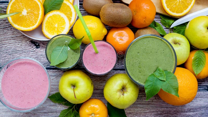 Zielony koktajl i soczysta owoc na drewnianym tle detoxification fotografia stock Zielony koktajl i soczysta owoc na drewnianym tle detoxification fotografia stock
