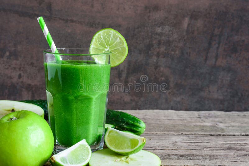 Zielony zdrowy smoothie w szkle z szpinakiem, jabłkiem, ogórkiem i wapnem z słomą, Detox napój
