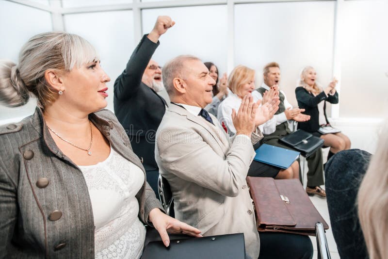 Side view. smiling business seminar listeners applauding together. business and education. Side view. smiling business seminar listeners applauding together. business and education