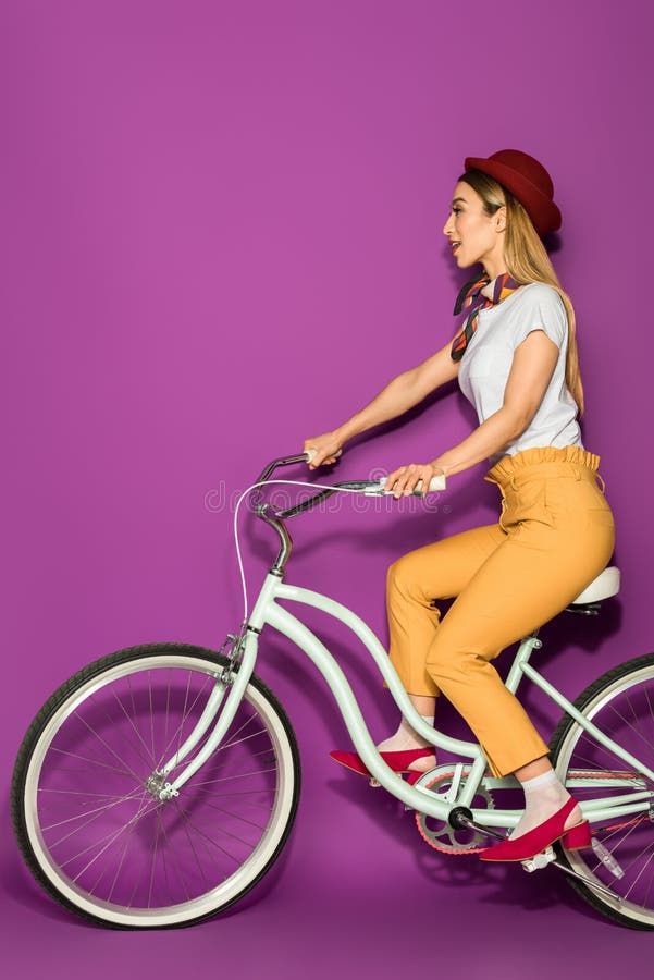 zijaanzicht van aantrekkelijke modieuze Aziatische meisje berijdende fiets en weg het kijken royalty-vrije stock afbeeldingen zijaanzicht van aantrekkelijke modieuze Aziatische meisje berijdende fiets en weg het kijken royalty-vrije stock afbeeldingen