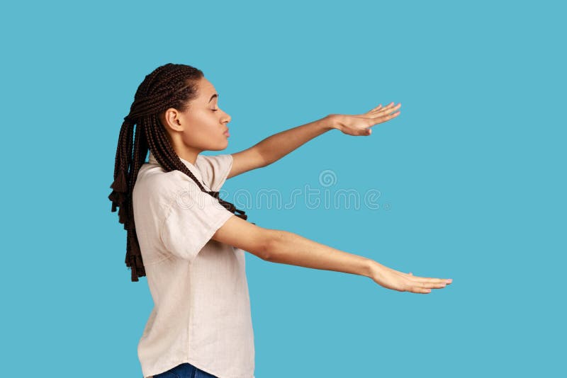 Side view of blind woman with outstretched hands walking alone with closed eyes in darkness, feels disoriented confused, lost road, wearing white shirt. Indoor studio shot isolated on blue background. Side view of blind woman with outstretched hands walking alone with closed eyes in darkness, feels disoriented confused, lost road, wearing white shirt. Indoor studio shot isolated on blue background.