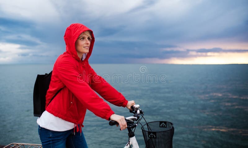 Zijaanzicht van een vrouw met een fiets die buiten op het strand staat Kopieerruimte stock foto Zijaanzicht van een vrouw met een fiets die buiten op het strand staat Kopieerruimte stock foto