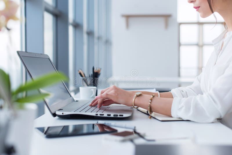 Zijaanzichtportret van vrouw het werken in huis-bureau als telewerker, het typen en het surfen Internet, die het werkdag hebben royalty-vrije stock fotografie Zijaanzichtportret van vrouw het werken in huis-bureau als telewerker, het typen en het surfen Internet, die het werkdag hebben royalty-vrije stock fotografie