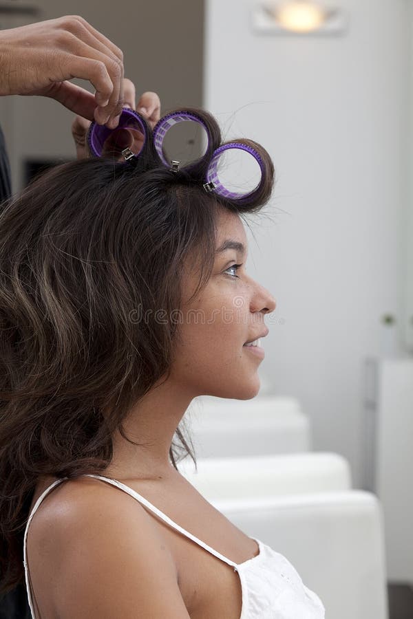 Side profile of young women wearing curlers. Side profile of young women wearing curlers