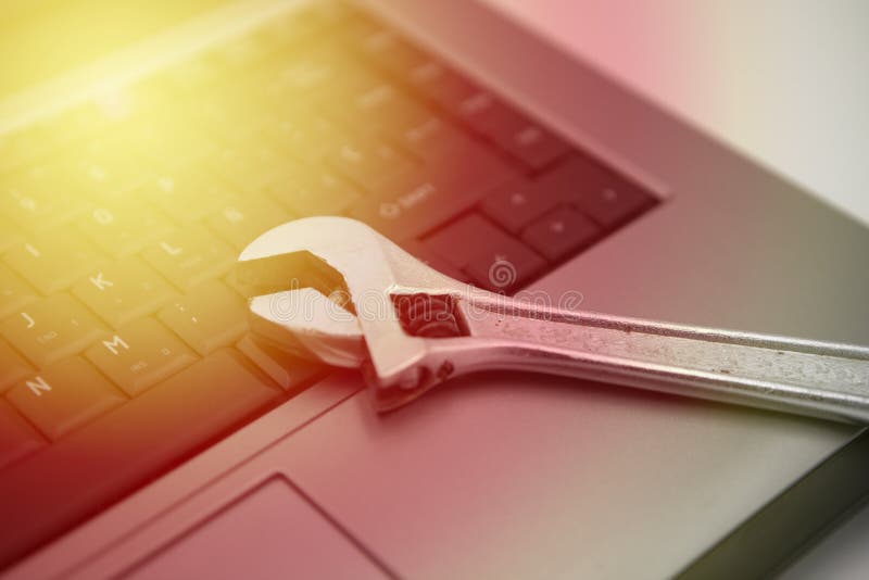 Zilveren toetsenbord met moersleutel, technische bijstand en computerreparaties, gouden licht royalty-vrije stock afbeeldingen Zilveren toetsenbord met moersleutel, technische bijstand en computerreparaties, gouden licht royalty-vrije stock afbeeldingen
