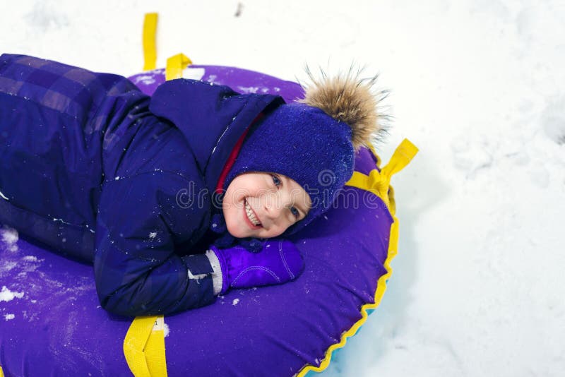 Zima portret szczęśliwa chłopiec w kapeluszu zmęczonego dziecka sledding tubing zdjęcie royalty free Zima portret szczęśliwa chłopiec w kapeluszu zmęczonego dziecka sledding tubing zdjęcie royalty free