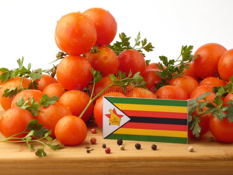 Zimbabwe flaga na drewnianym panelu z pomidorami odizolowywającymi na whit zdjęcia stock