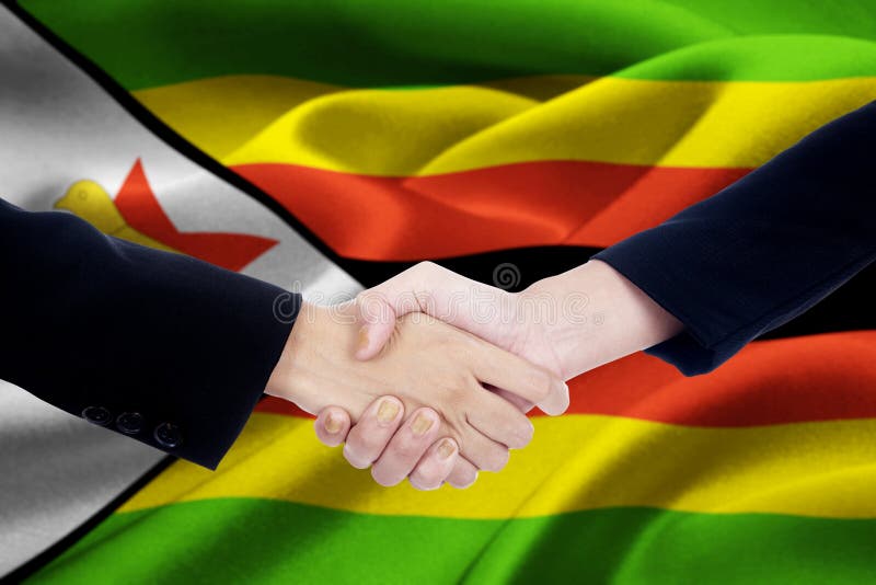 Zimbabwe flaga z dwa przedsiębiorców uściskiem dłoni fotografia royalty free