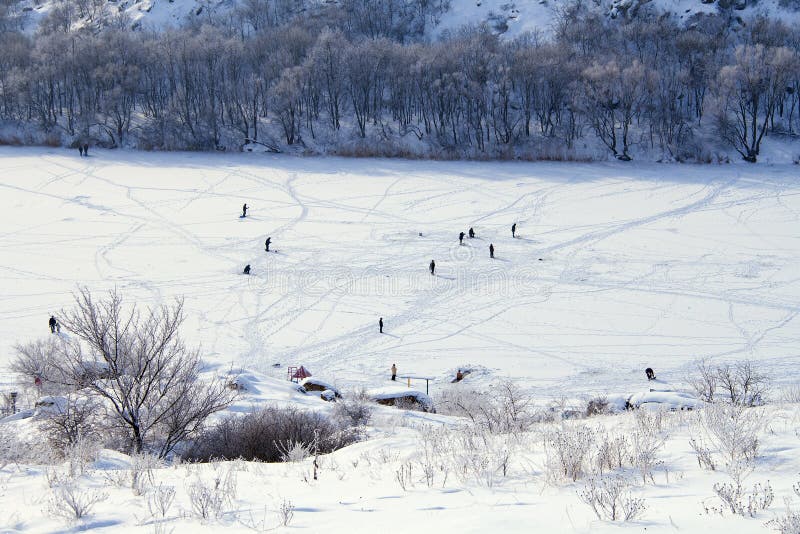 Cold winter. Frozen river. Lot of peoples on ice walking, fishing and even swiming in hole. Cold winter. Frozen river. Lot of peoples on ice walking, fishing and even swiming in hole.