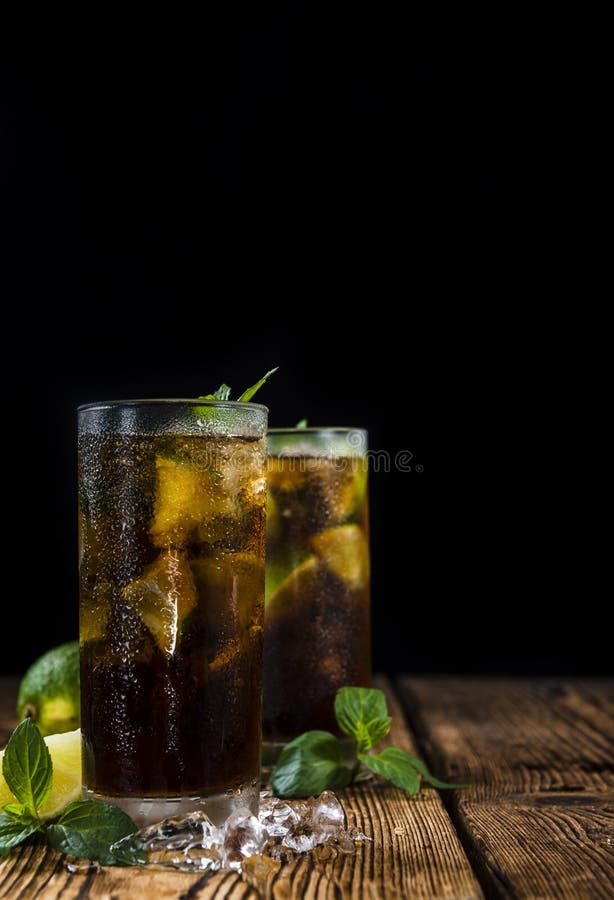 Zimny Longdrink (Kuba Libre). Zimny Longdrink z brown rumem i świeżym wapnem na nieociosanym drewnianym tle (Kuba Libre)