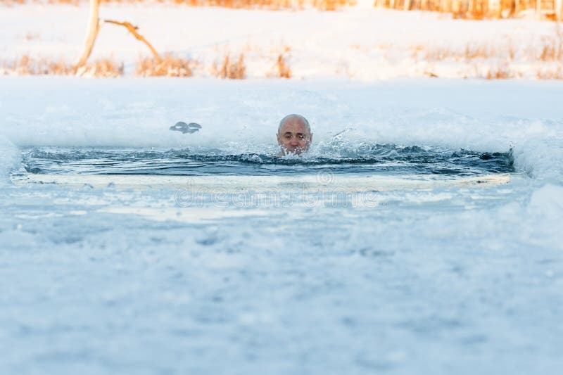 Winter swimming. Man in an ice-hole outdoors. Winter swimming. Man in an ice-hole outdoors