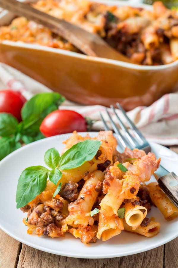 Ziti bolognese на белой плите, сотейник макаронных изделий с семенить мясом, томатный соус и сыр, вертикальные стоковое фото Ziti bolognese на белой плите, сотейник макаронных изделий с семенить мясом, томатный соус и сыр, вертикальные стоковое фото