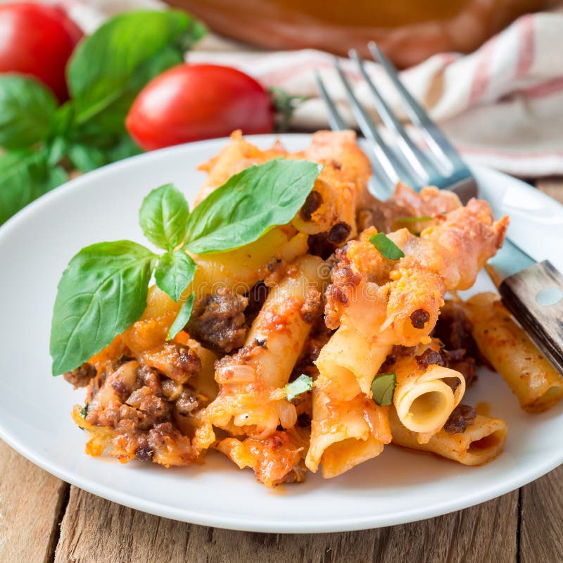Ziti bolognese на белой плите, сотейник макаронных изделий с семенить мясом, томатный соус и сыр, квадрат стоковые изображения rf Ziti bolognese на белой плите, сотейник макаронных изделий с семенить мясом, томатный соус и сыр, квадрат стоковые изображения rf