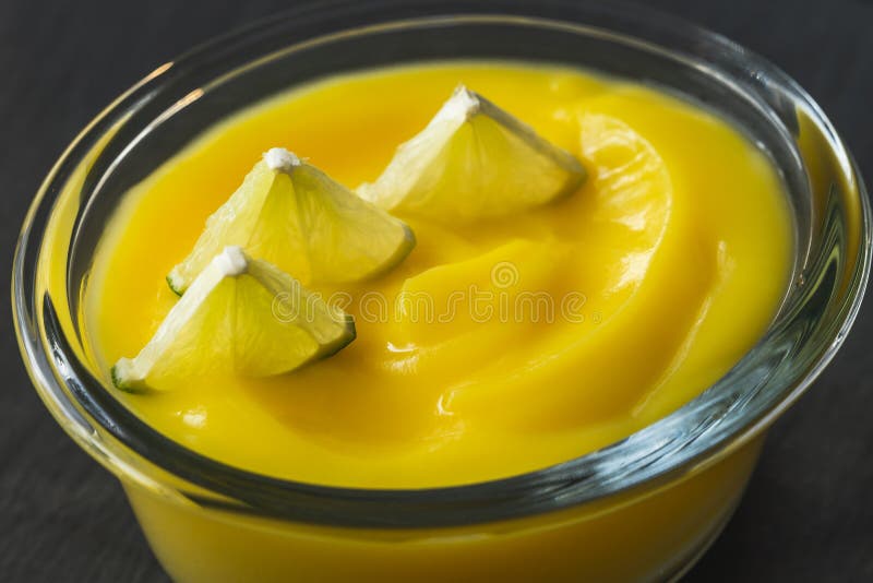 Zitronenpudding in einer Glasschüssel serviert mit geschnittener Zitrone lizenzfreies stockfoto