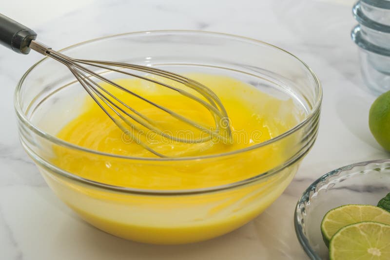 Zitronenpuddingrezept. mischende Bestandteile in einer Glasschüssel stockbild