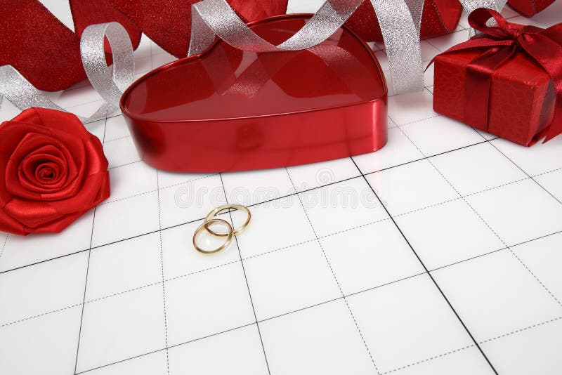 Ziua Valentinei și conceptul de nuntă aurie verighete în formă de inimă roșie cupă cu panglică strălucitoare și floare de trandafi stock image