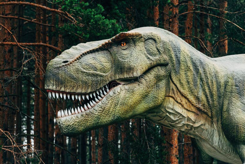 Tyrannosaurus rex or T-rex dinosaur in theme park surrounded with tall pine trees