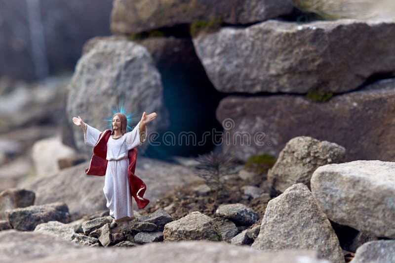 Zmartwychwstały jezus chrystus stojący przed wejściem do grobu. stoi wśród skał.