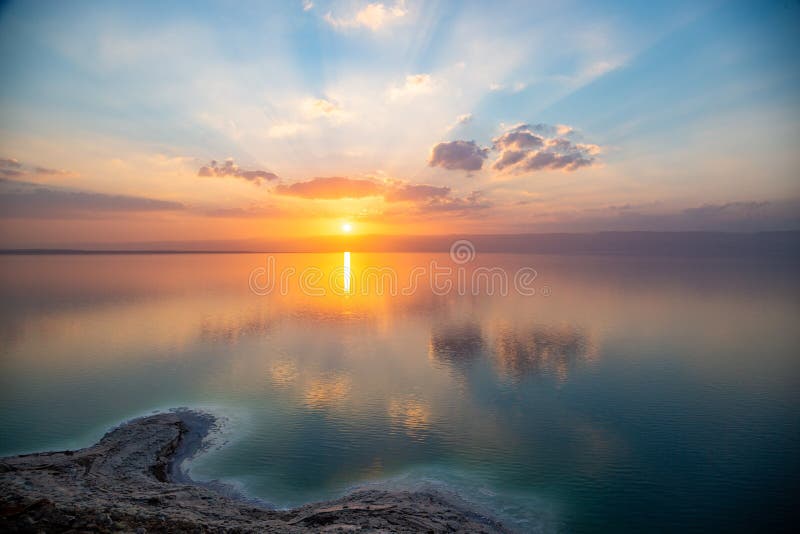 Zmierzch nad Nieżywym morzem, widok od Jordania Izrael i góry Judea, Odbicie słońce, nieba i chmury, Słona plaża, sól