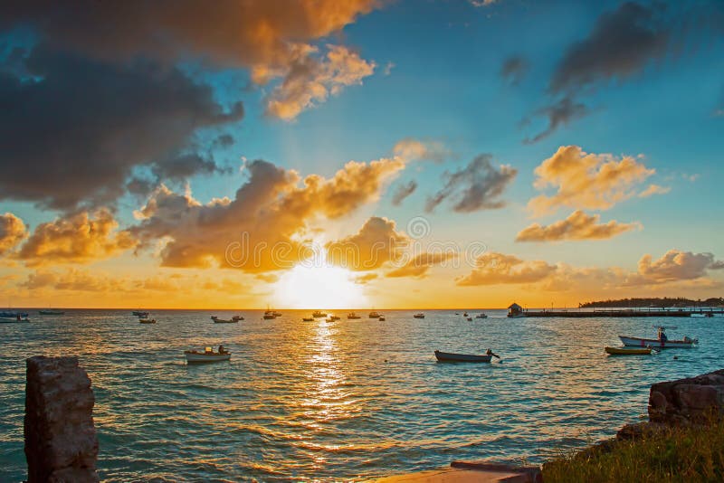 Beautiful Sunset viewed from Oistins fishing village in Barbados. Shows several boats and the jetty used to berth the fishing boats with their fish catches. Beautiful Sunset viewed from Oistins fishing village in Barbados. Shows several boats and the jetty used to berth the fishing boats with their fish catches.