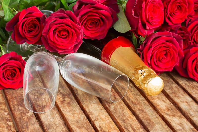 Valentine's day fresh dark red roses and couple of glasses with neck of champagne wine. Valentine's day fresh dark red roses and couple of glasses with neck of champagne wine