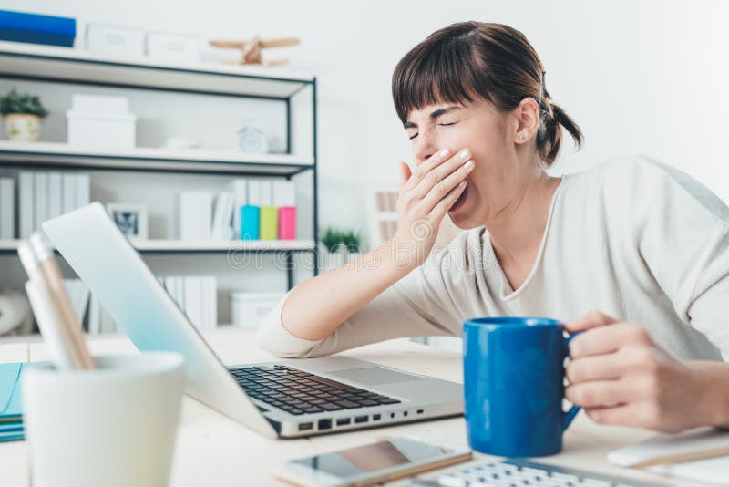 Zmęczona kobieta przy biurowym biurkiem zdjęcie stock Zmęczona kobieta przy biurowym biurkiem zdjęcie stock