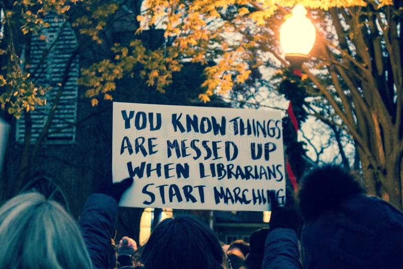 Columbus, Oh. November 2016. Candlelight vigil after the presidential election of Donald Trump. Person holds up sign stating `You know things are messed up when librarians start marching`. Columbus, Oh. November 2016. Candlelight vigil after the presidential election of Donald Trump. Person holds up sign stating `You know things are messed up when librarians start marching`