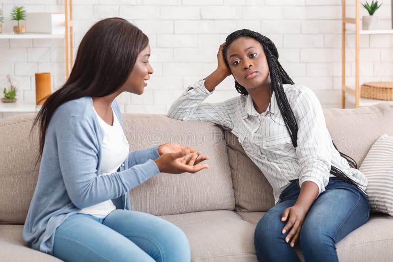 Znudzona młoda afro kobieta zmęczona słuchaniem swojej gadającej dziewczyny