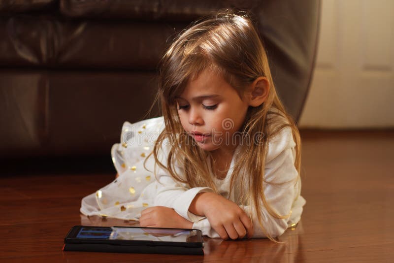 Zoet 4 éénjarigenmeisje in wit, die met iPad spelen stock afbeelding Zoet 4 éénjarigenmeisje in wit, die met iPad spelen stock afbeelding