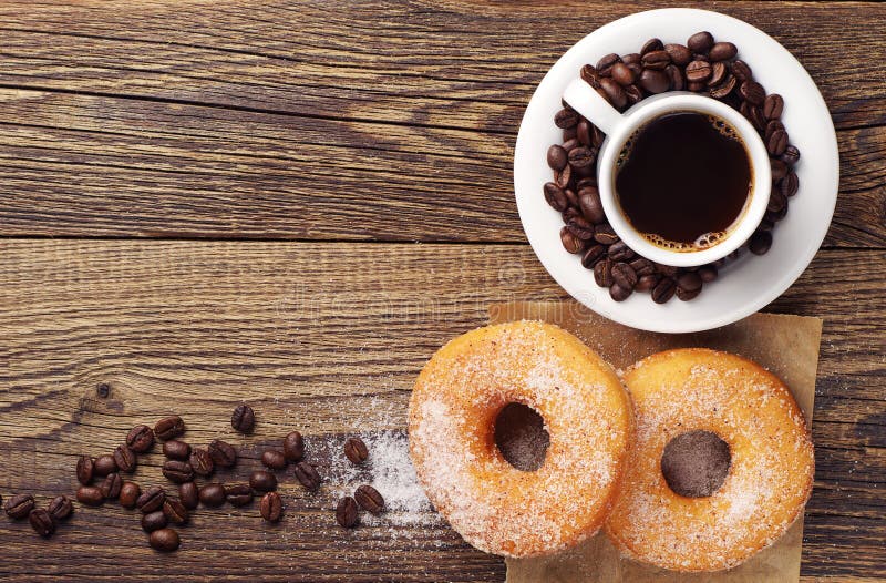 Breakfast with sweet donut and coffee on wooden table. Top view. Breakfast with sweet donut and coffee on wooden table. Top view