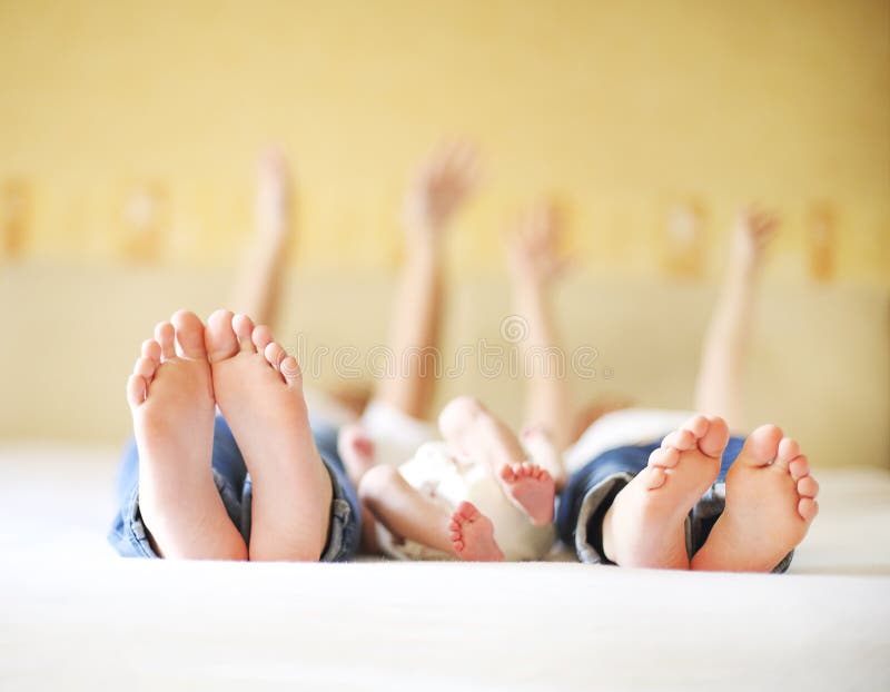 Zoete familie in bed Drie zusters, sluiten omhoog op voeten stock fotografie Zoete familie in bed Drie zusters, sluiten omhoog op voeten stock fotografie