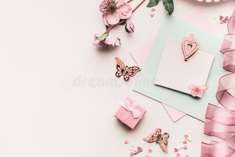 Zombe acima do cartão feminino dos feriados na cor pastel pálida com flores, caixa de presente, fita e coração no backgrou branco