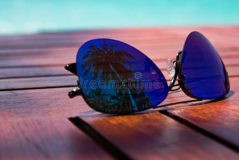 zomer Stijlglazen met palmbezinning die op een houten lijst aangaande de kust van de Caraïbische Zee de plaats bepaalde van royalty-vrije stock foto zomer Stijlglazen met palmbezinning die op een houten lijst aangaande de kust van de Caraïbische Zee de plaats bepaalde van royalty-vrije stock foto