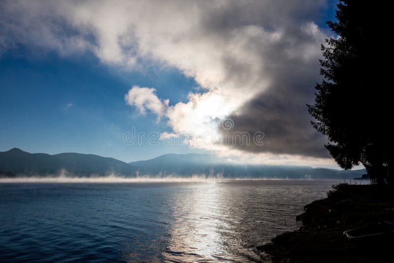 Zon die uit wolken met waterverdamping komen stock fotografie Zon die uit wolken met waterverdamping komen stock fotografie