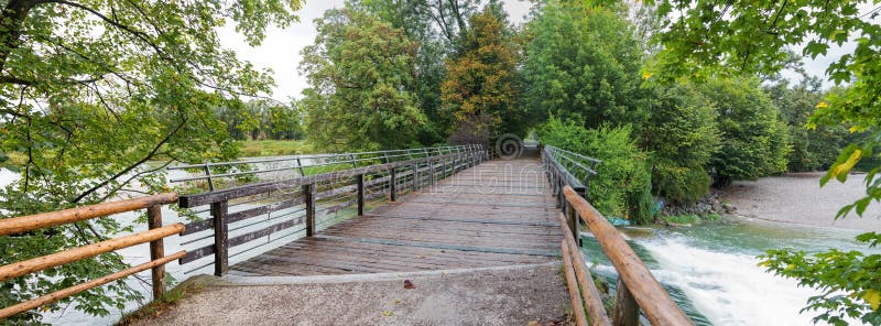 Popular recreational area in munich, walkwa and Flaucher bridge over isar river with green branches. Popular recreational area in munich, walkwa and Flaucher bridge over isar river with green branches