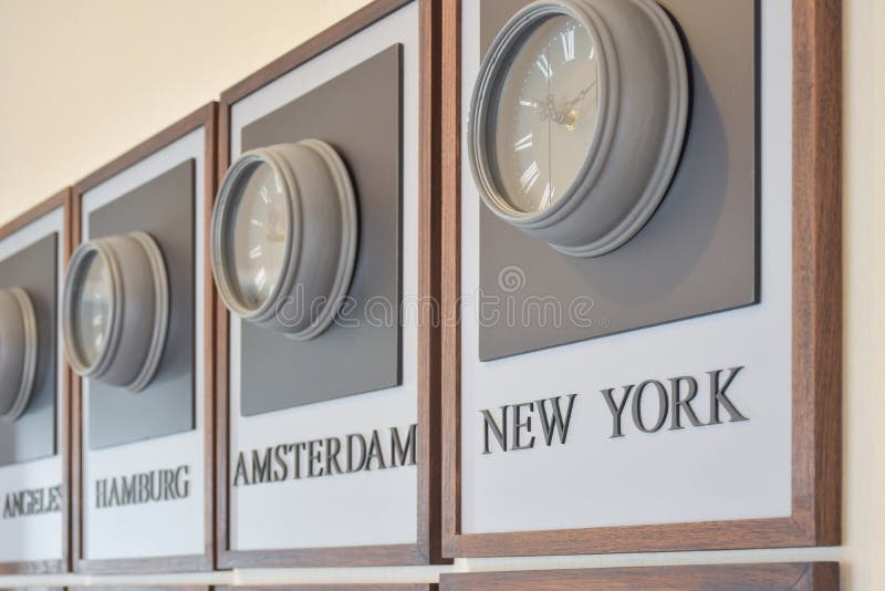 Zonas de momento diferente del reloj en la pared. Relojes de madera que muestran el tiempo en diversas ciudades del mundo en la pared