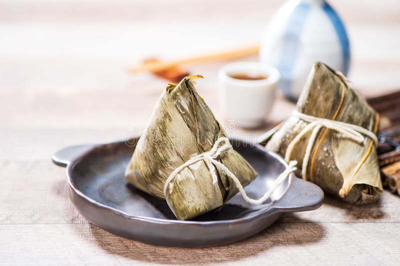 Zongzirice dumpling with a cup of tea on a wood table, Dragon Boat Festival, Asian traditional food