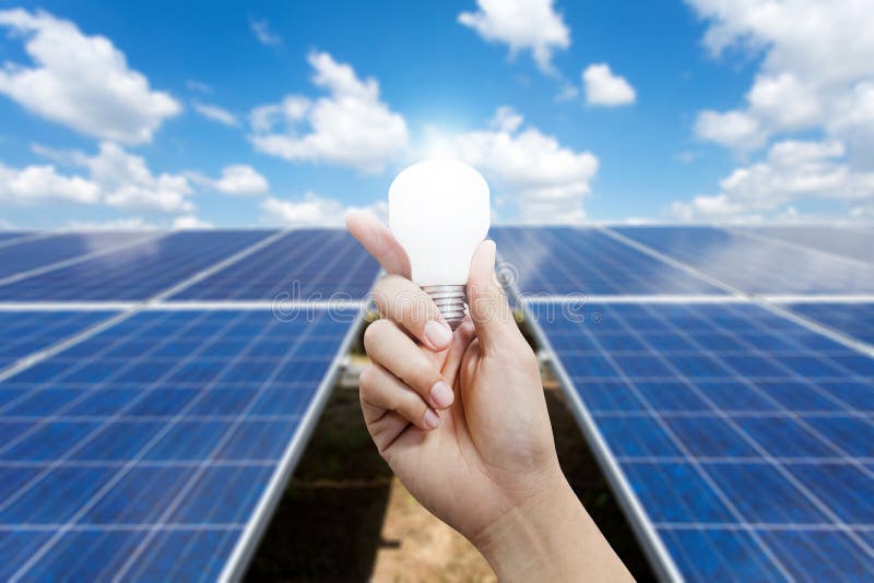 Solar energy panels and Light bulb in hand, Green energy concept. Solar energy panels and Light bulb in hand, Green energy concept