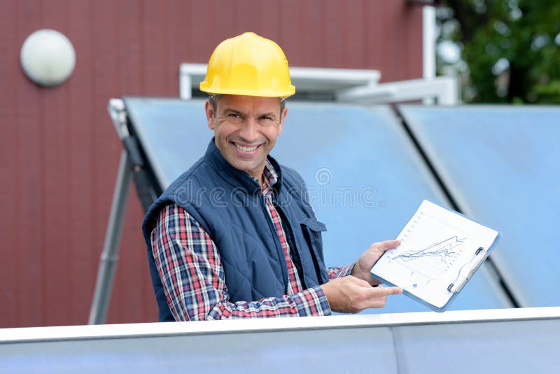 Zonnepaneelinstallateur die besparingsgegevens tonen royalty-vrije stock foto Zonnepaneelinstallateur die besparingsgegevens tonen royalty-vrije stock foto